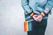 © amazing studio - Asian lady wearing blue jean jacket or denim shirt and holding rainbow color flag, symbol of LGBT pride month celebrate annual in June social of gay, lesbian, bisexual, transgender, human rights.