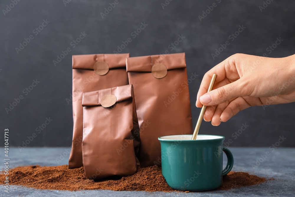 Female hand stirring coffee in cup on table