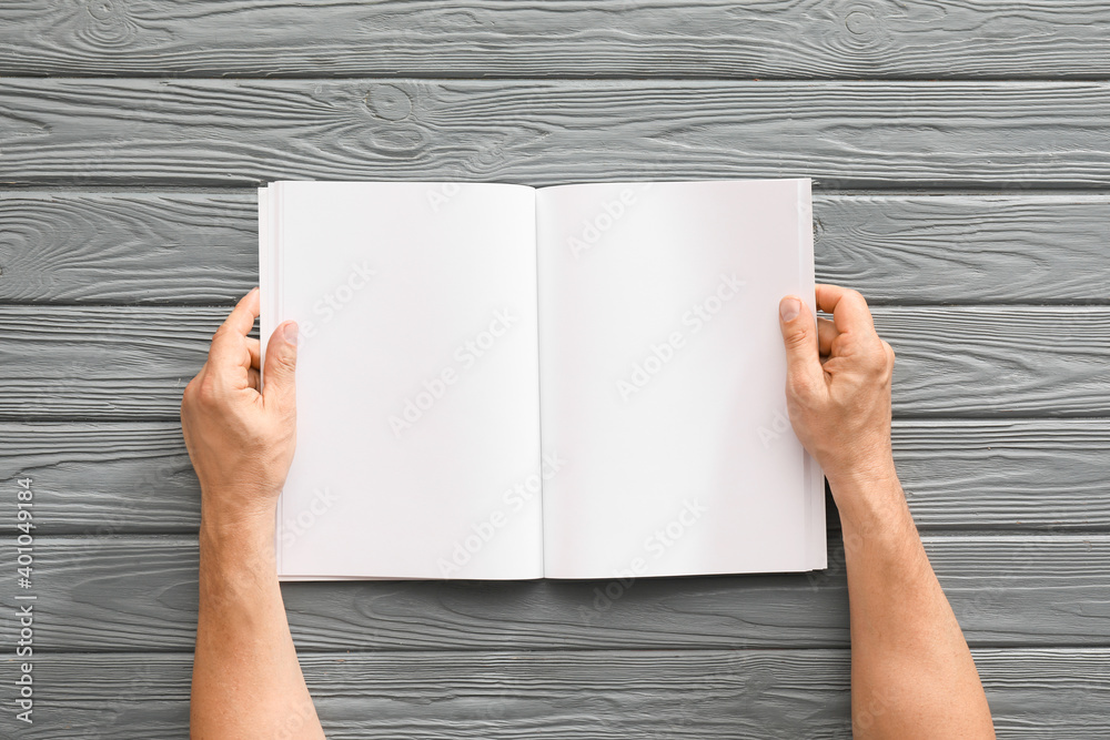 Old man with blank magazine at table