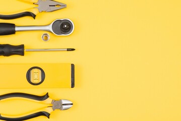 Carpenter tools set on yellow background, top view