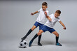 © Roman - two soccer players interfere with each other, compete. studio portrait of young football players