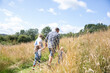 © Sam Edwards/Caia Image - Family holding hands walking in sunny idyllic rural field