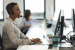 © Paul Bradbury/Caia Image - Businesswoman with headset working at computer in call center office