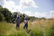 © Sam Edwards/Caia Image - Parents carrying daughters on shoulders in sunny rural summer field