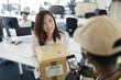 © Paul Bradbury/Caia Image - Happy businesswoman receiving packages from courier in office
