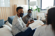 © Paul Bradbury/Caia Image - Business people in face masks discussing paperwork in office meeting