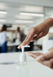© Paul Bradbury/Caia Image - Close up businesswoman using hand sanitizer pump in office