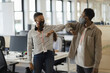 © Paul Bradbury/Caia Image - Business people in face masks elbow bumping in office