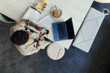 © Paul Bradbury/Caia Image - Businessman using smart phone at laptop in office