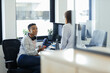 © Paul Bradbury/Caia Image - Businesswomen talking at computer in office