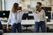 © Paul Bradbury/Caia Image - Businesswomen in face masks elbow bumping in office