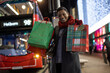 © Tom Merton/Caia Image - Portrait happy young woman with Christmas gifts in city at night