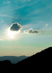 Poster - abstract nature poster concept of landscape photography mountain silhouette in evening clear weather time with sun behind cloud and blue sky background scenic view