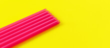 Six Pink Plastic Drinking Straws On Yellow Board, Forming Diagonal Line - Abstract Closeup Detail