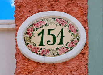 Street sign number 154 on a textured wall 