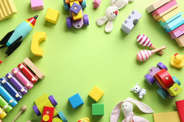 Poster - Frame made of different toys on green background, flat lay. Space for text