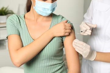 Wall Mural - Doctor giving injection to patient in hospital, closeup. Vaccination day