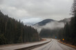 © Liudmila - Highway with road signs on the sides among high mountains in the clouds in winter, along which trucks and cars travel. Idaho, USA, 12-5-2020