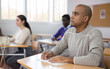 © JackF - Portrait of confident man sitting in class working during group business training