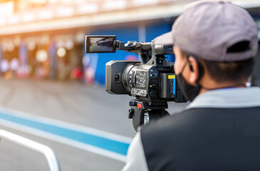 Poster - Video camera operator working with his equipment. video cinema production. Covering an event with a video camera. Professional video man hand holding camera operator camcorder working.