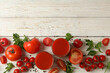 Glasses with tomato juice, tomatoes and spices on wooden background