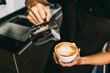 © artitwpd - Crop image of a young male barista pouring hot milk into hot espresso black coffee for making Latte Art.