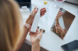 © Svitlana - Hands of young woman and bottle of cream on desk background