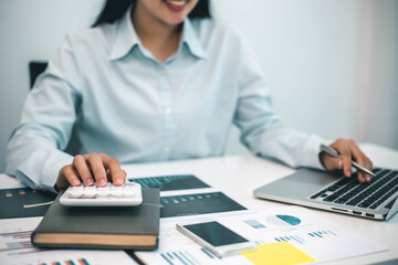 businessman working on desk office with using a calculator to calculate the numbers, finance accounting concept