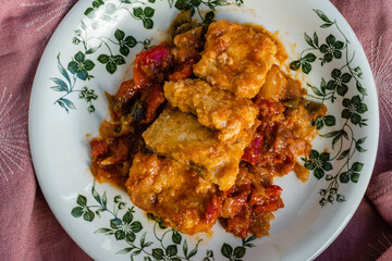 Wall Mural - Cod with red peppers, tomato and onion with knife and fork