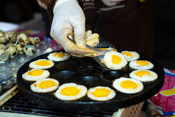 Wall Mural - street food in Thailand. Fried eggs. Scrambled eggs for take away