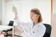 © bnenin - Female chemist working with a sample and a dropper.