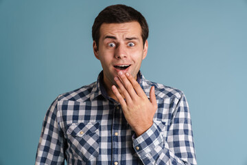 Excited young casual man gesturing isolated