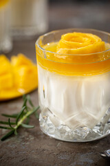 Wall Mural - Italian dessert panna cotta with mango in glass on gray background