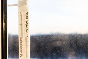 Canvas Print - first frost - outdoor thermometer on home window lit by dawn sun shows slightly low temperature and blurred forest on background (focus on the thermometer )