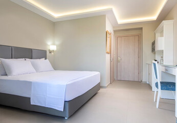 Classic style white interior of hotel bedroom, bathroom, kitchen in single space of modern small studio apartment flat