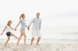 © momentimages/Tetra Images - Parents with daughter (10-11) walking on beach