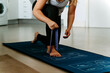© Jake Jakab/ADDICTIVE STOCK - Cropped unrecognizable sportswoman in activewear performing arms exercise by using elastic band while working out on mat at home
