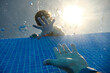 © Philippe Degroote/ADDICTIVE STOCK - From below view of faceless boys hand reaching for sinking in swimming pool water males hand