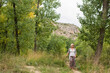 © Si And Si/ADDICTIVE STOCK - Full length of female traveler strolling alone on narrow trail amidst green trees in forest in summer day