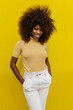 © Victor Torres/ADDICTIVE STOCK - Portrait of a curly haired black woman looking at camera in front of a yellow background