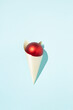 © Dani Enamorado/ADDICTIVE STOCK - Top view of red shiny Christmas ball in paper cone in shape of ice cream placed on blue background