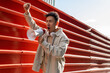 © David Munoz/ADDICTIVE STOCK - Agitating Asian male screaming in megaphone while standing with fist up near red metal fence and looking away in rage
