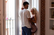 © Manuel Ruiz/ADDICTIVE STOCK - Side view of loving man embracing passionate girlfriend while standing together near window in cozy apartment in morning looking at each other