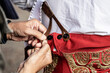 © Manu Vega/ADDICTIVE STOCK - Closeup of unrecognizable male fastening buttons on traditional red costume of matador preparing for corrida event