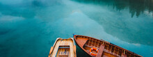 From Above Wooden Boat With Paddles Floating On Turquoise Water Of Calm Lake On Background Of Majestic Landscape Of Highlands