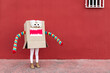 © Sergio Victor Vega/ADDICTIVE STOCK - Unrecognizable playful kid wearing funny costume of monster made of carton box standing on street during holiday celebration
