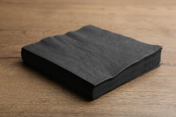 Wall Mural - Stack of black clean paper tissues on wooden table
