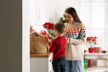 Sticker - Mother and son with Christmas gifts at home. Advent calendar in basket