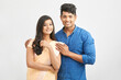 © krishna - Cheerful Indian young couple in traditional outfit against white.