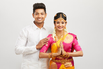 Wall Mural - Attractive south Indian couple greeting namaste in traditional dress